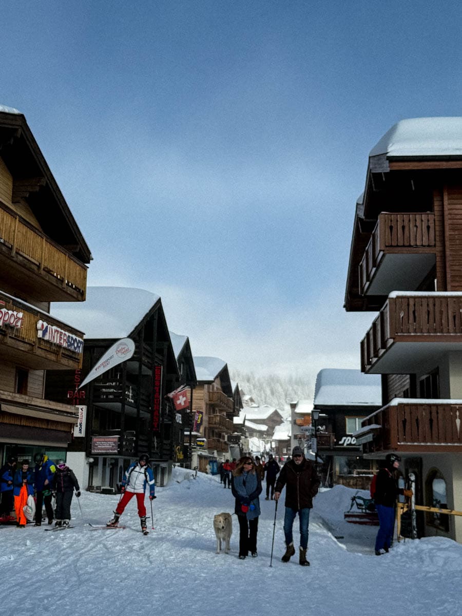 vue de la rue principale de Bettmeralp Suisse; skieur, promeneurs avec chien et chalets suisses
