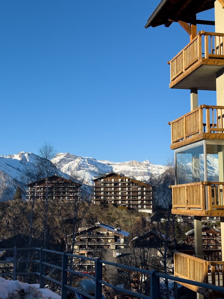 vue sur les Alpes, ciel bleu, immeuble style chalet suisse en bois