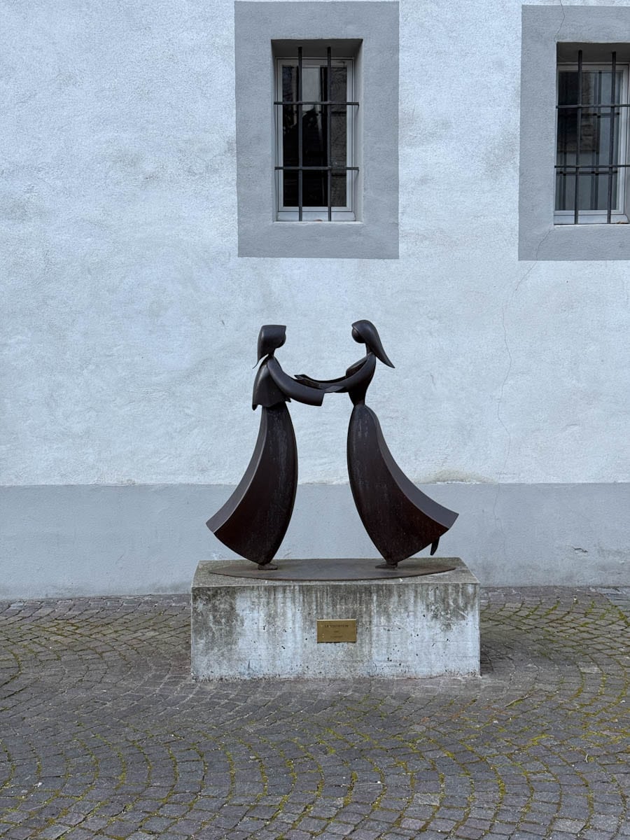 statues de femmes devant immeuble blanc