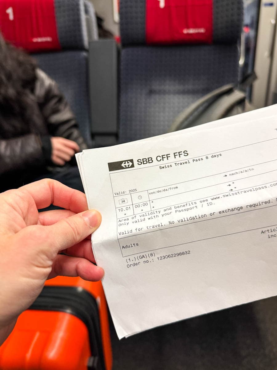 main tenant une swiss travel pass dans un wagon de train suisse