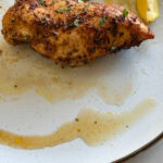 poitrine de poulet grillée et son jus dans une assiette blanche