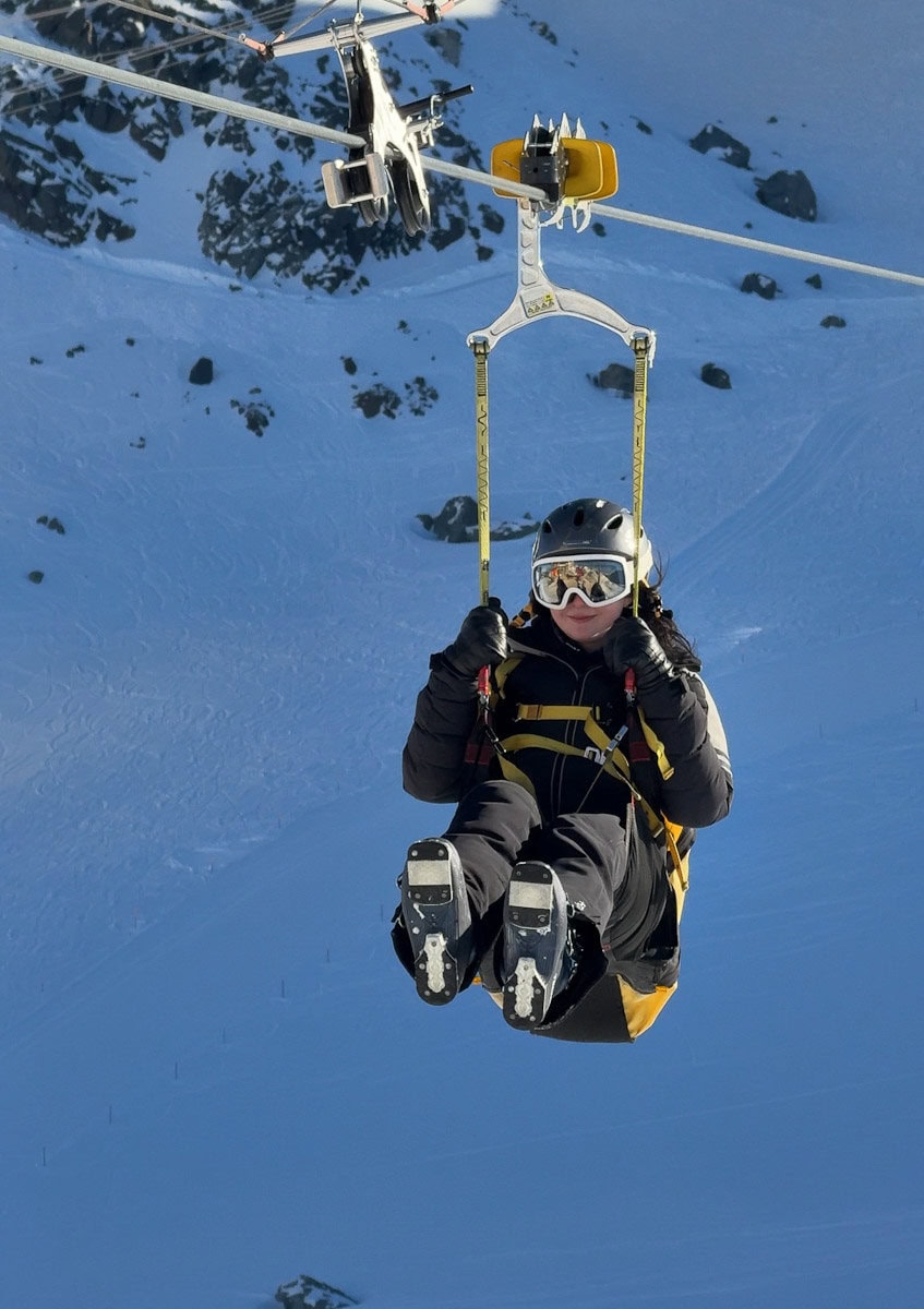 fille en zipline hivernale devant montagnes suisses