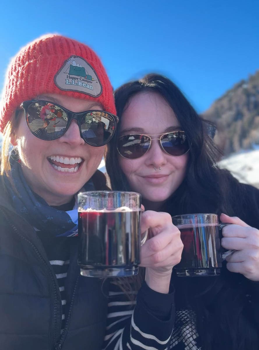 mere-fille trinquant au vin chaud en terrasse