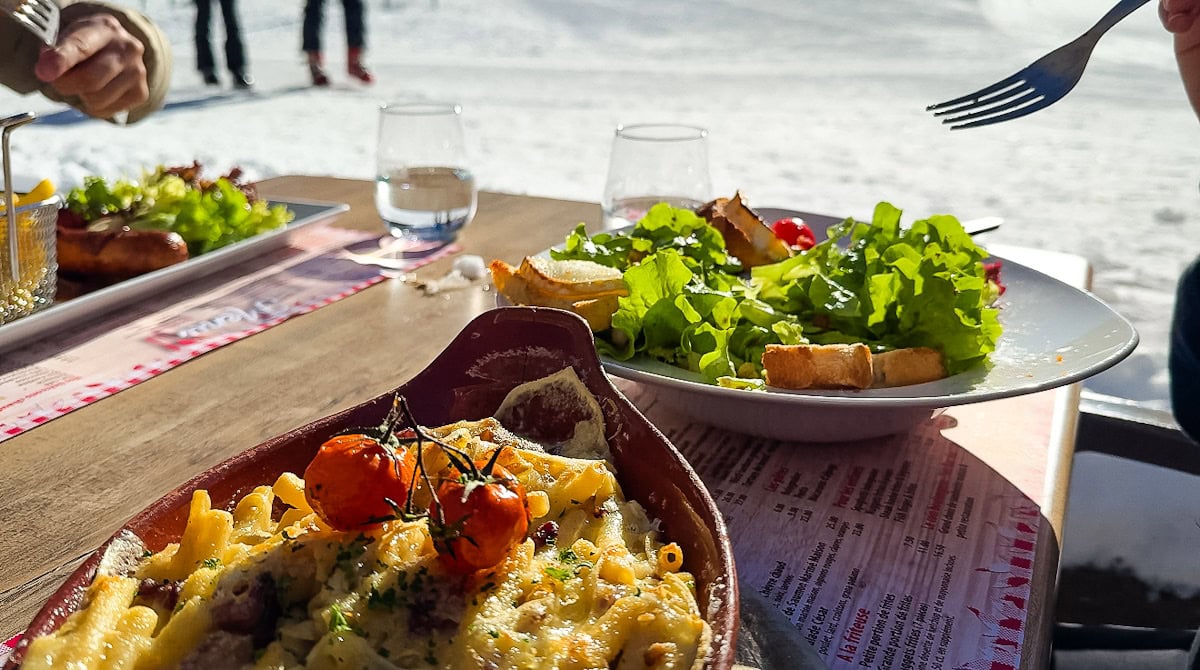 assiettes gourmandes vue sur neige en terrasse