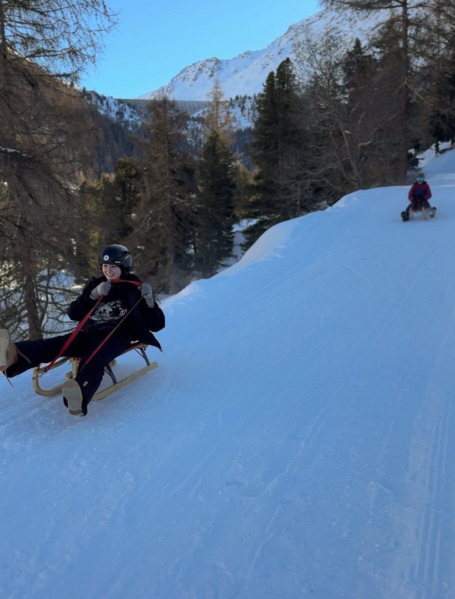 deux filles en luge en suisse vue montagnes