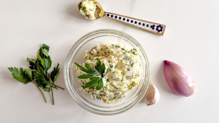 bol de beurre à l'ail avec persil, échalote, gousse d'ail et une cuillère avec beurre