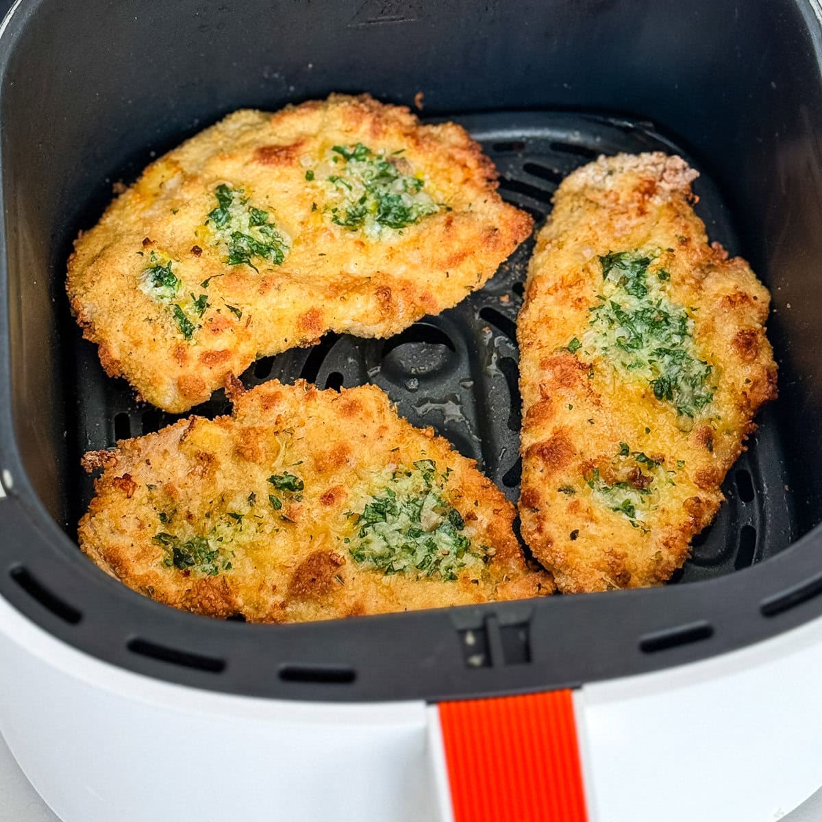 2 escalopes de poulet panées au beurre à l'ail dans panier du air fryer