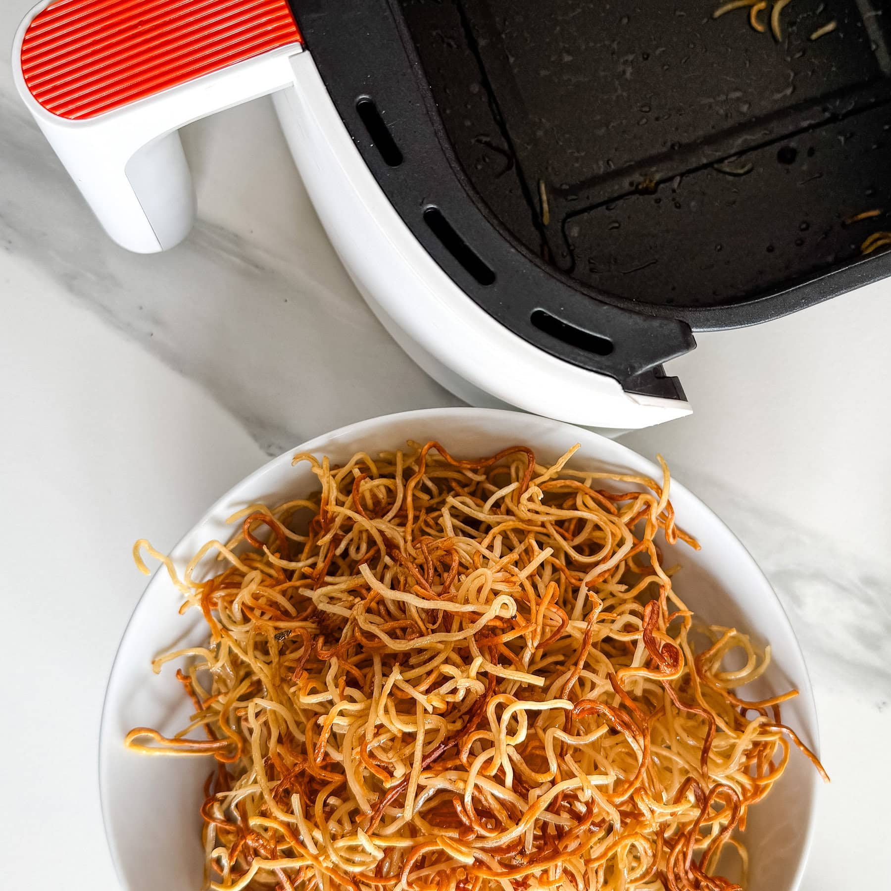 nouilles chinoises croustillantes dans un bol devant airfryer
