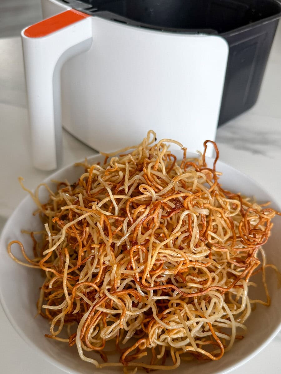 bol de nouilles frites asiatiques devant un air fryer