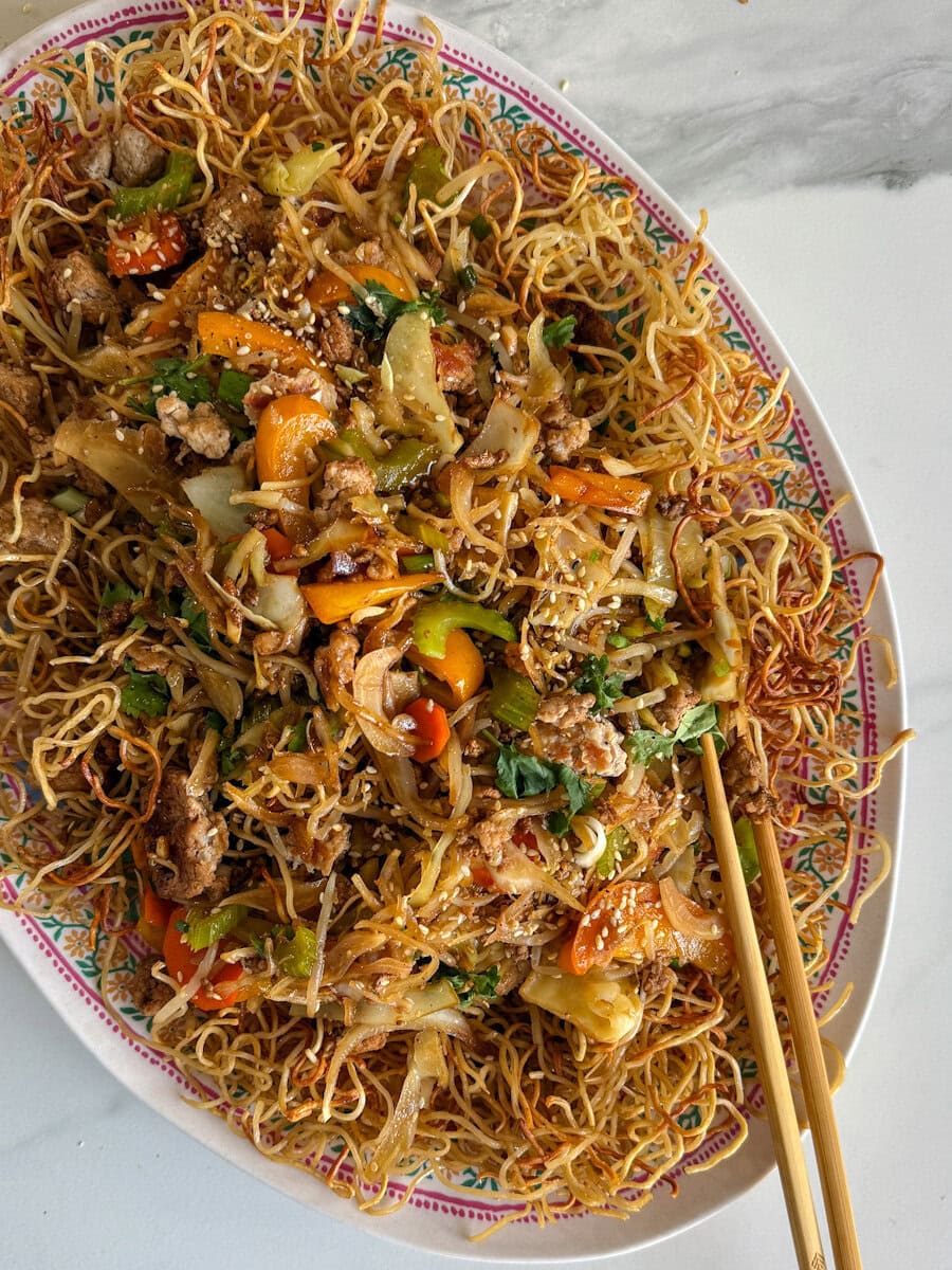 chow mein au porc et légumes dans un grand plat ovale avec chopsticks