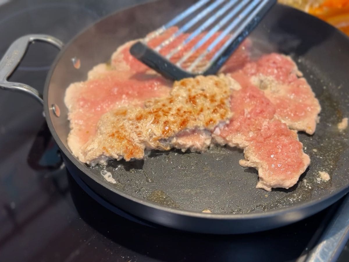 porc haché grillé dans la poêle avec spatule
