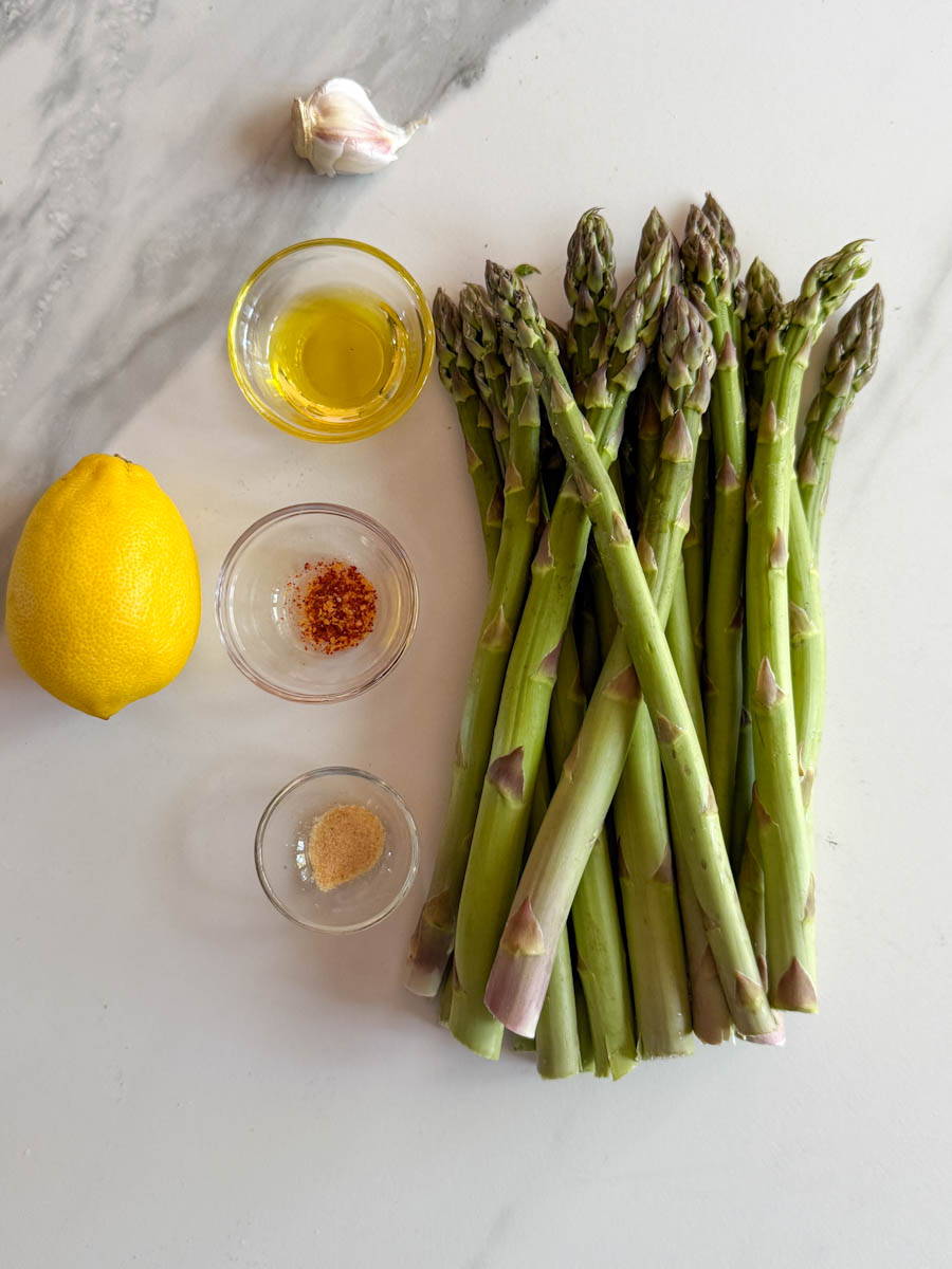 asperges sur comptoir blanc avec assaisonnements et citron