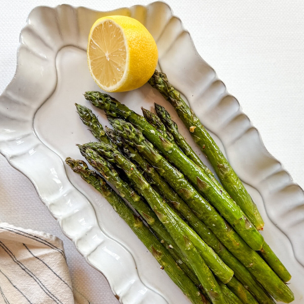asperges grillées avec citron dans un plat de service blanc