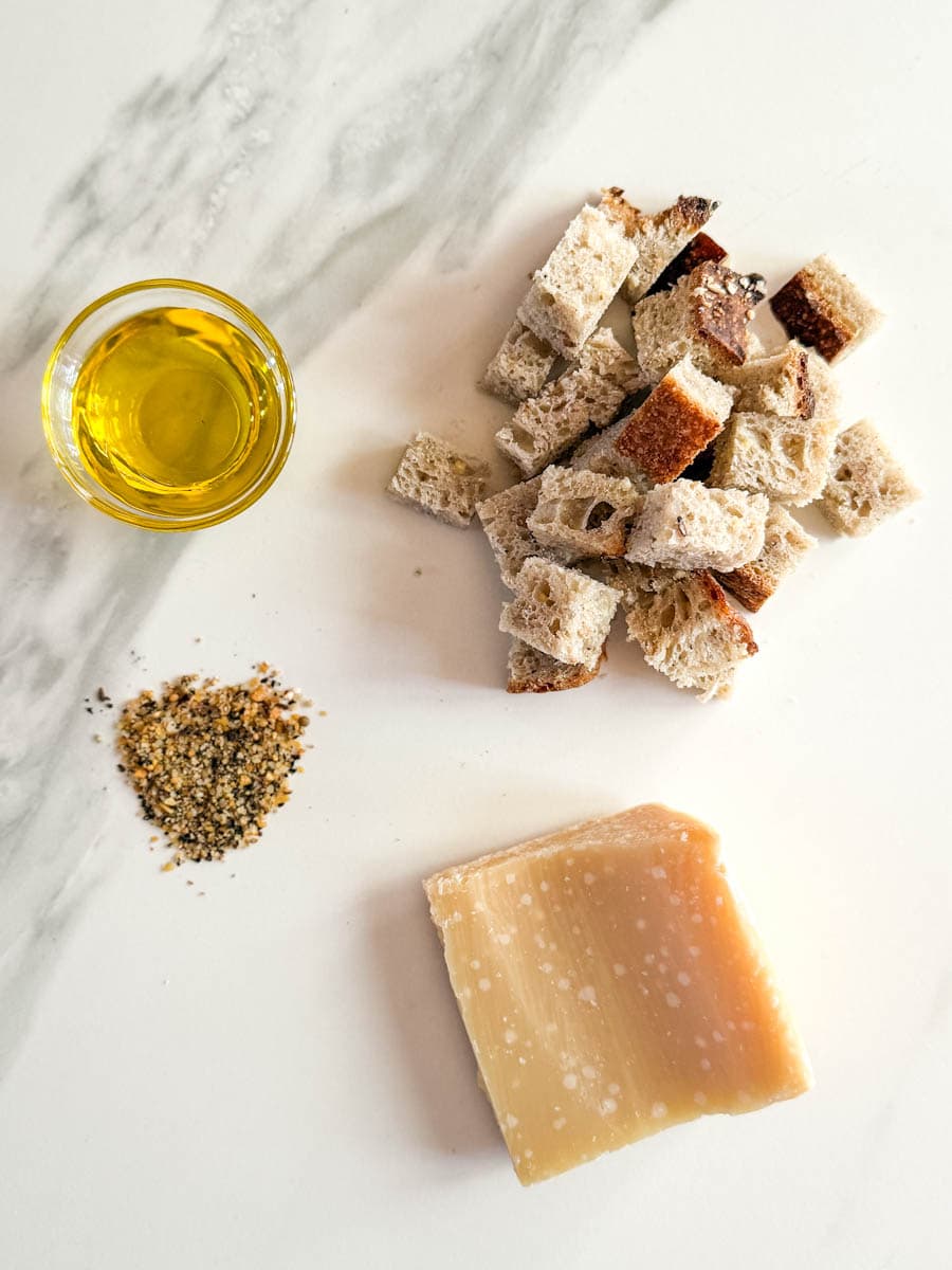 dés de pain rassis, croute de fromage parmesan, épices à steak et huile d'olive sur comptoir