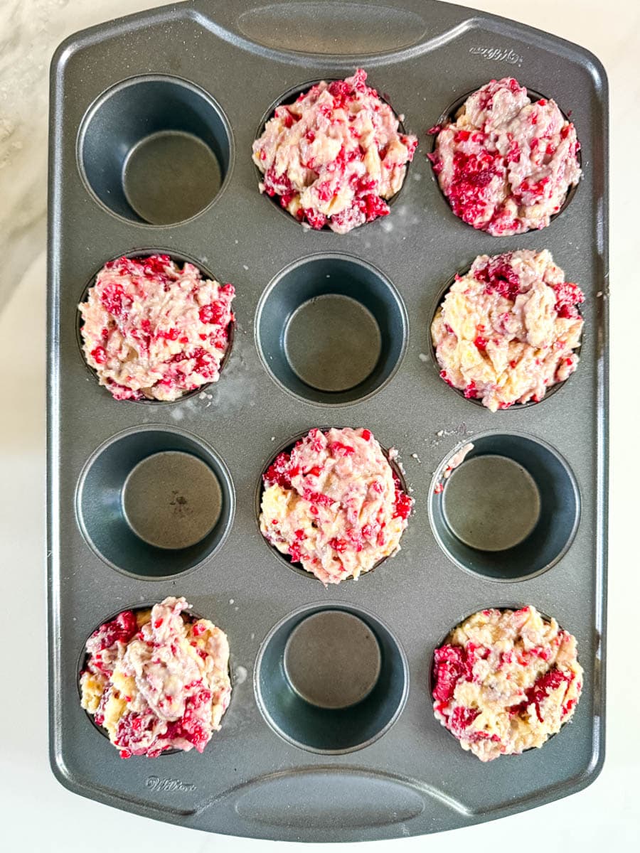 pâte à muffins aux framboises non cuite dans moule à muffin répartis en tic tac toe
