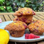 3 muffins aux framboises dans une assiette, avec framboises citron sur la table