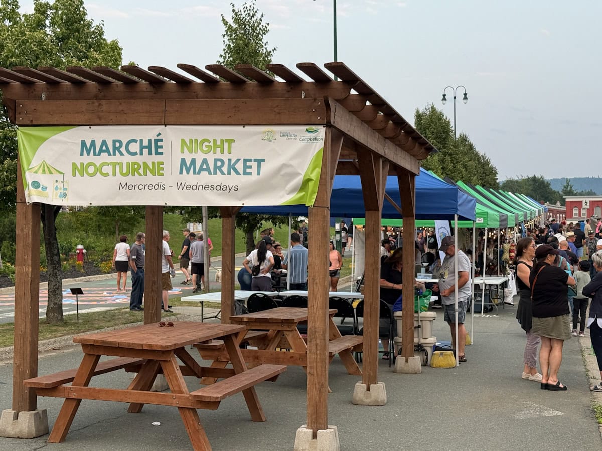marché nocture de Campbellton, kiosques, gens qui circulent et affiche du marché