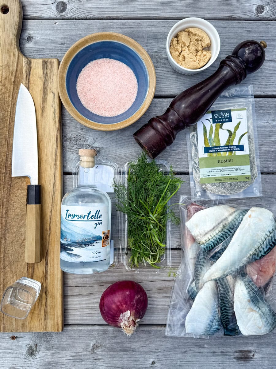 ingrédients et outils pour gravlax sur table de bois: couteau, planche, oignon aneth, poivre, sel, sucre