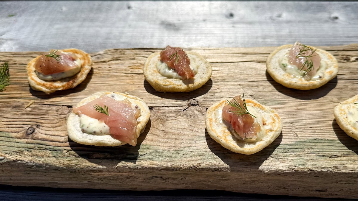 blinis (6) avec gravlax de maquereau sur une planche de bois