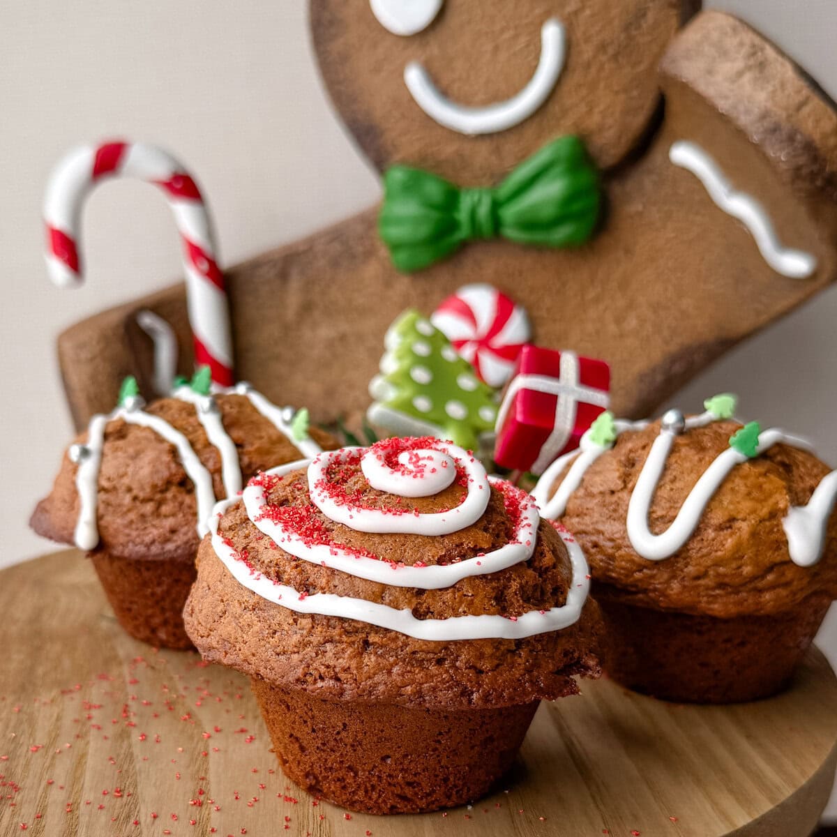 3 muffins aux pain d'épices sur présentoir devant bonhomme pain d'épice géant