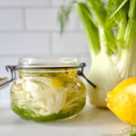 pot de fenouil mariné avec bulbe de fenouil et citron sur comptoir blanc