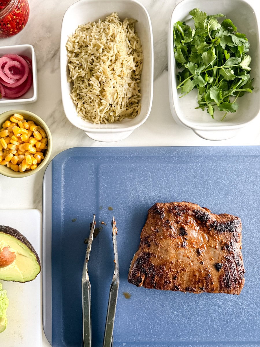 mise en place steak chipotle sur comptoir: steak, avocat, riz, laitue, tomate, maïs