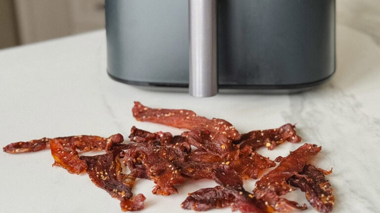 jerky de porc sur comptoir blanc devant panier du air fryer